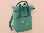 Green roll top twin handle backpack with an embroided design of cute space alien cat floating in the stars and the quote beam me up I want to leave!