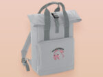Light Grey roll top twin handle backpack with an embroided design of cute crying pig and the quote please do not percive me